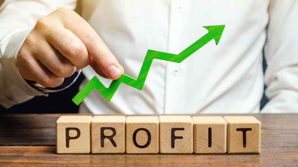 most profitable business in india - Image of the word 'profit' on a table with an arrow in an upward trajectory and a man behind it 